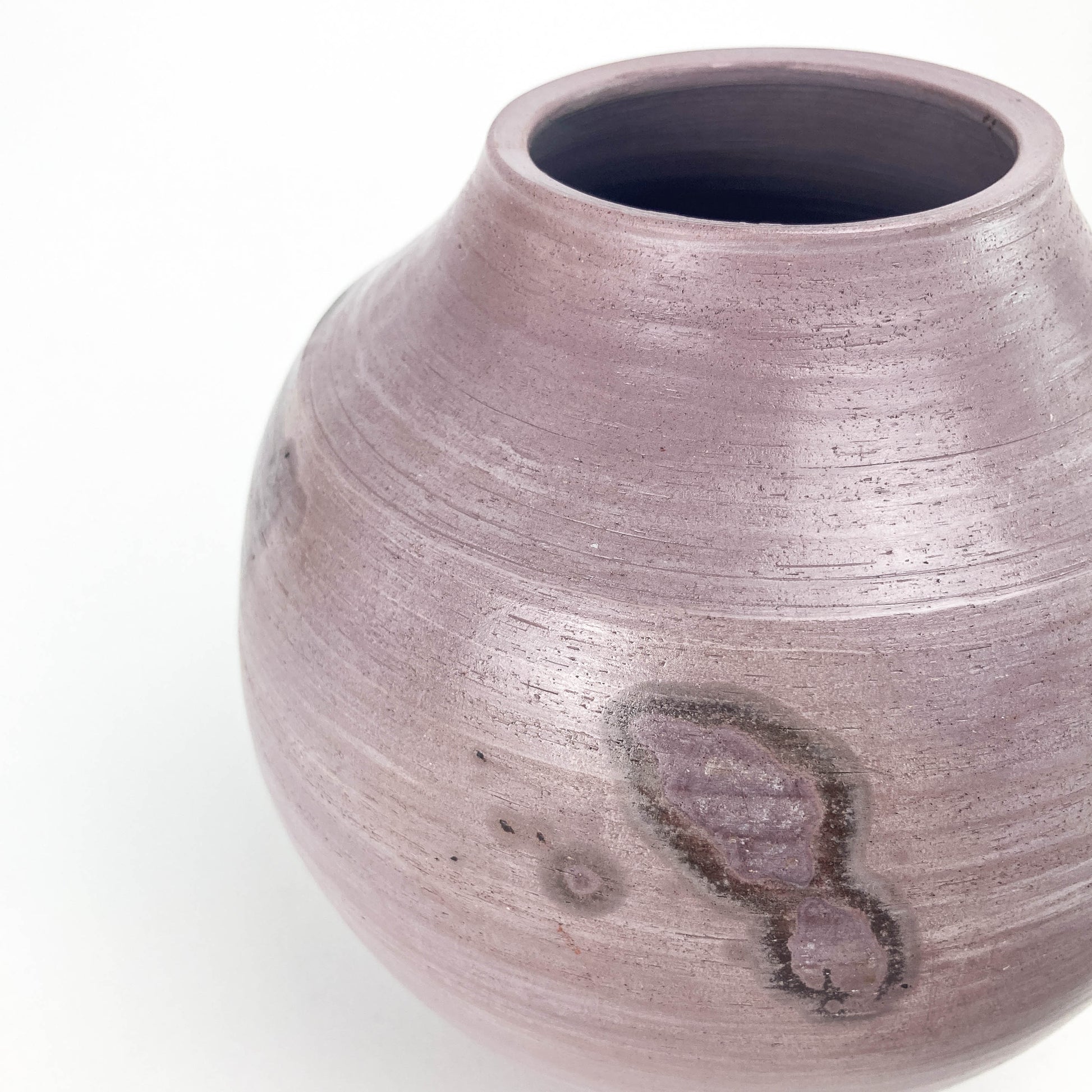 Textured ceramic jar with lid and colorful coiled wire decoration. Some marks on the jar's surface.