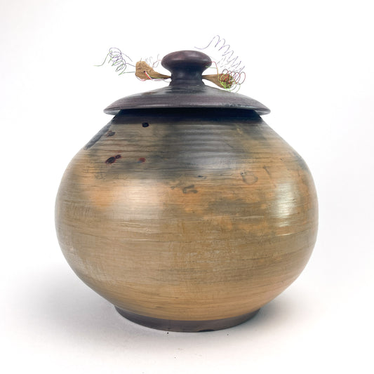 Handmade ceramic pot with lid and textured surface, featuring a dark brown knob and twine detail.
