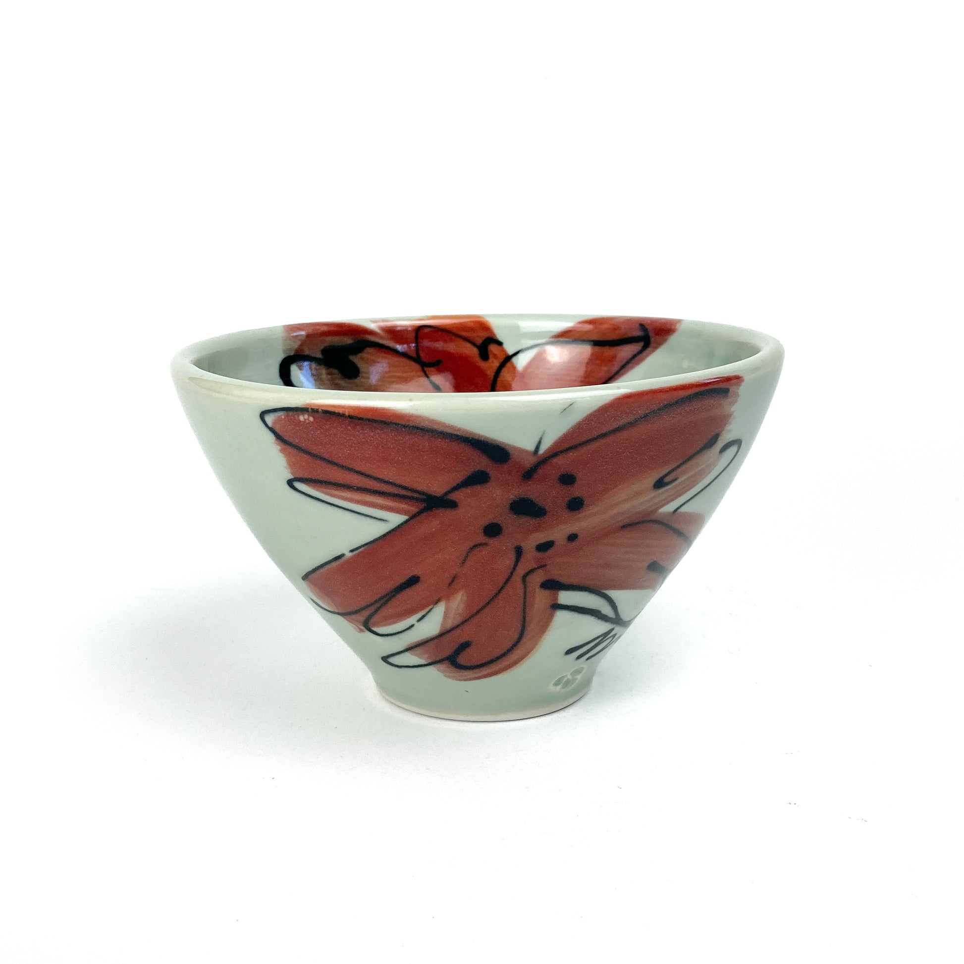 A small, conical ceramic bowl with a hand-painted floral design on its side. The bowl has a smooth, glazed finish.