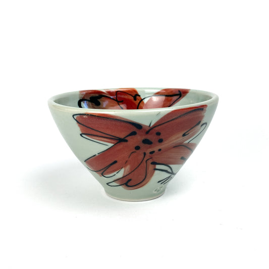 A small, conical ceramic bowl with a hand-painted floral design on its side. The bowl has a smooth, glazed finish.