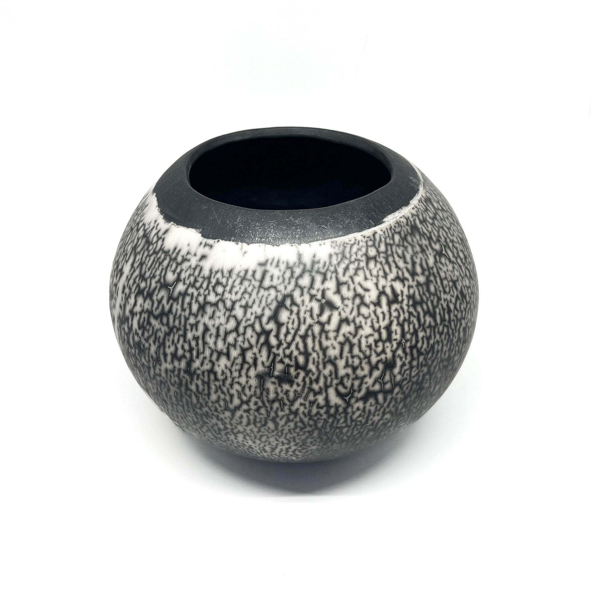 Round ceramic vase with a crackled black and white glaze and a contrasting black interior and rim.