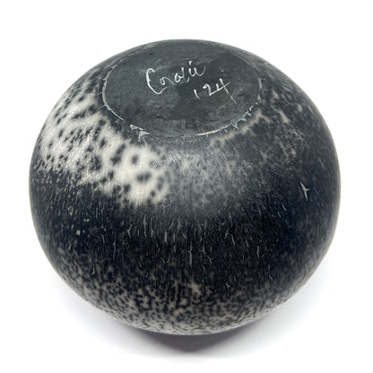 Round ceramic vase with a textured, crackled black and white glaze and handwritten text on the top.