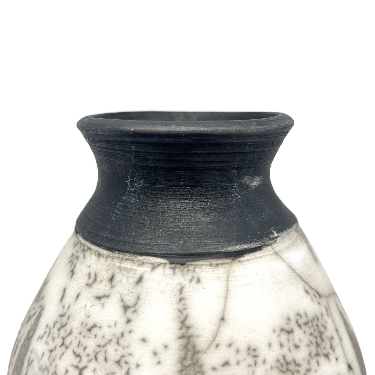 Close-up of the textured black neck and rim of a ceramic vase with a crackled white and black body.