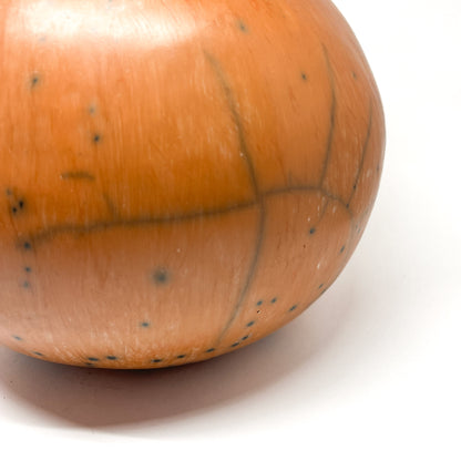 Close-up of the base of a round ceramic vase with a mottled, earthy-toned glaze and subtle crack lines.