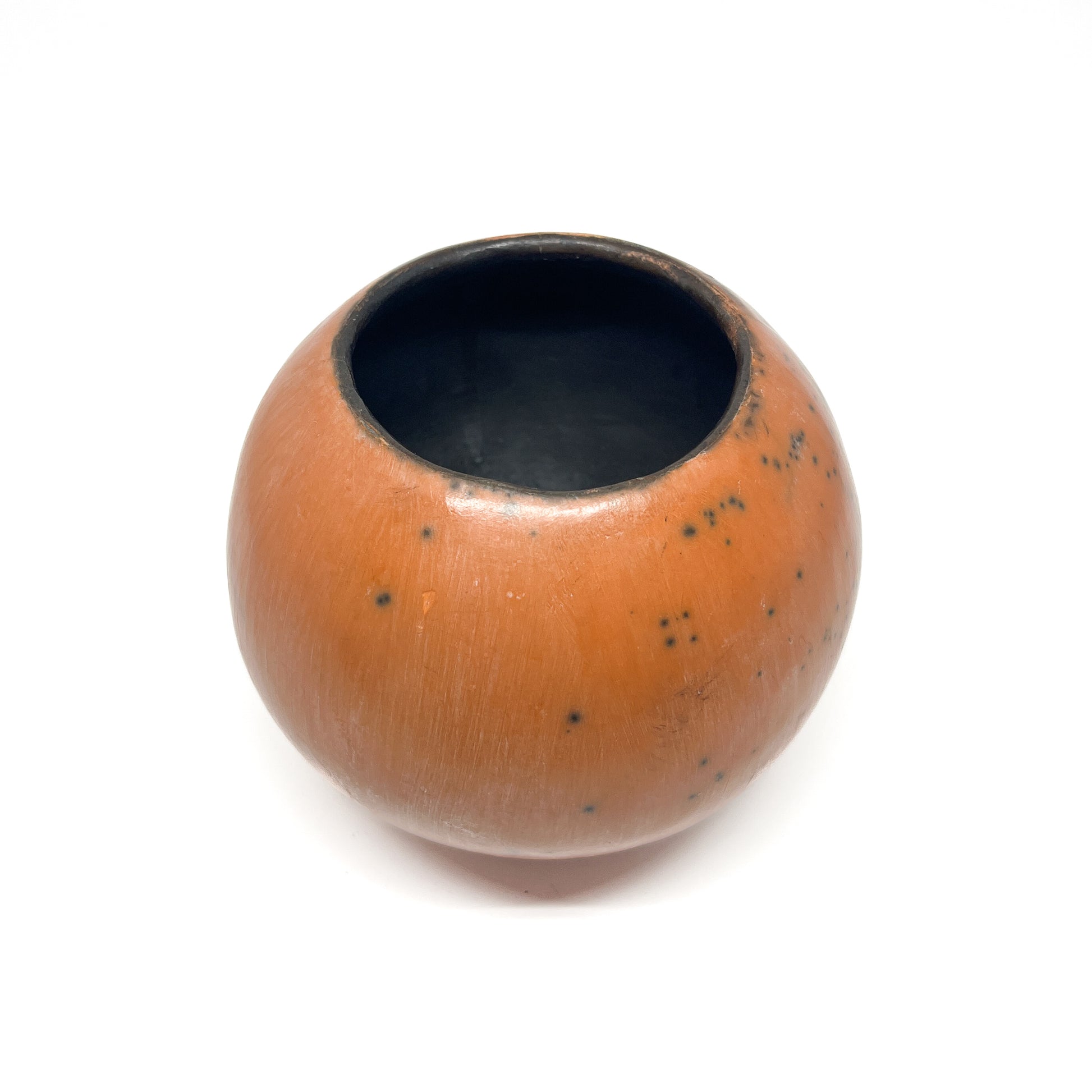 Round ceramic vase with a mottled, earthy-toned glaze and a dark, textured interior.
