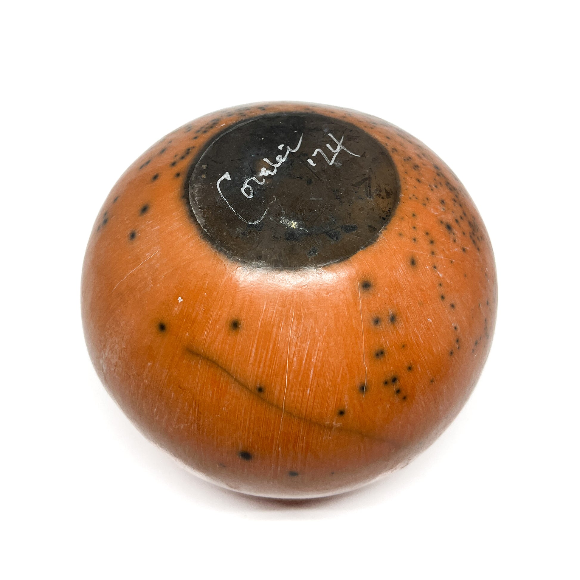 Top view of a round ceramic vase with a mottled glaze and handwritten text within a dark circular area.