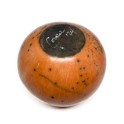 Top view of a round ceramic vase with a mottled glaze and handwritten text within a dark circular area.
