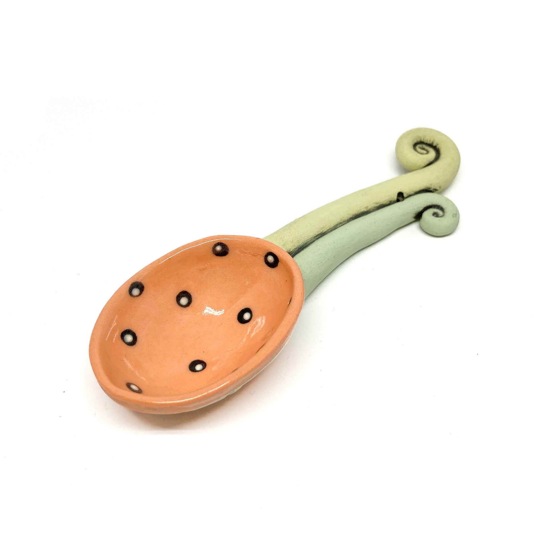 Funky spoon with glossy polka-dot bowl and a curled handle, crafted in a bold, artistic style.
