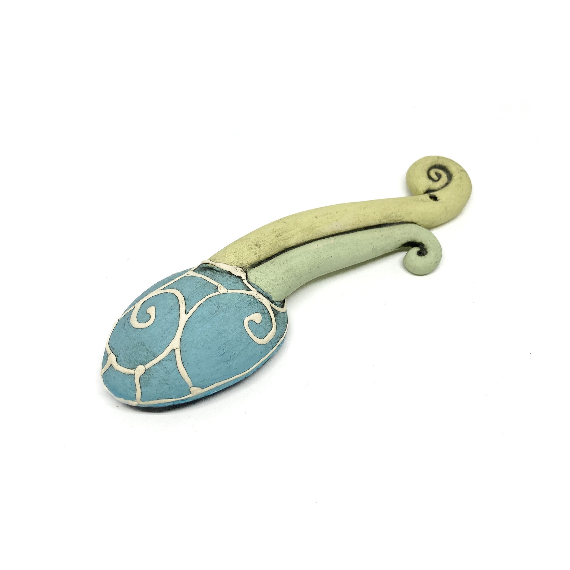 Back view of a funky spoon featuring etched swirls on the bowl and a curled, dual-tone handle.