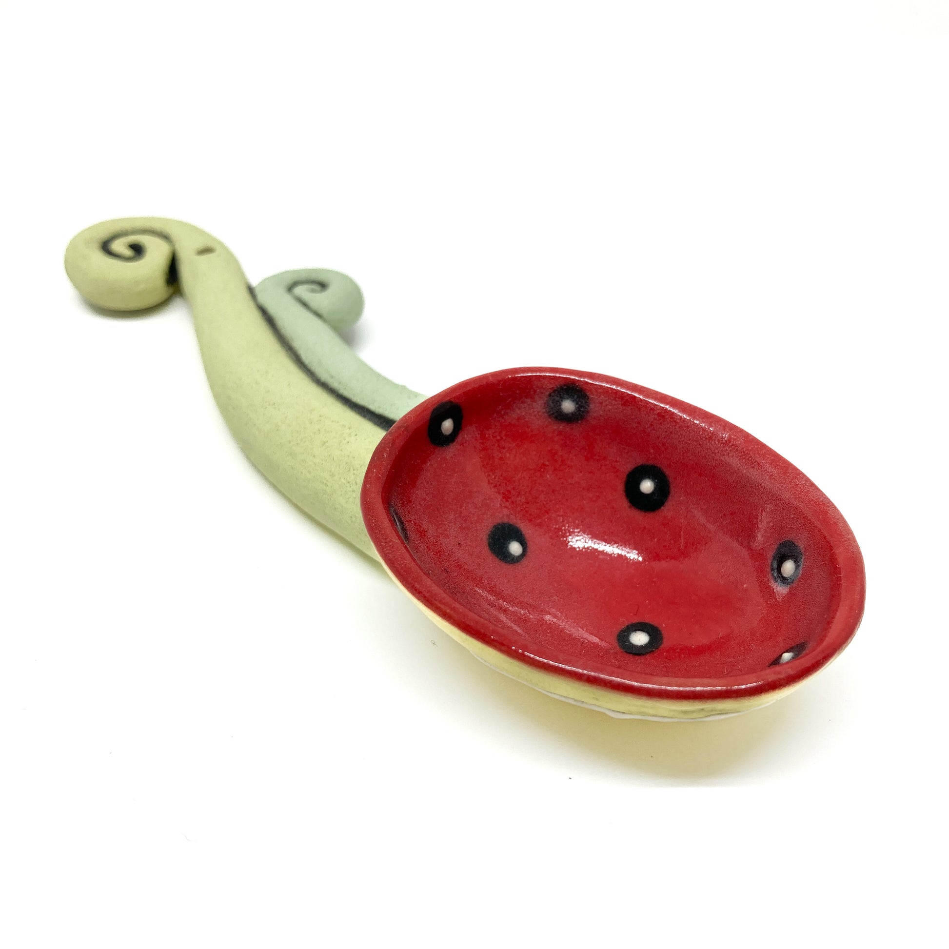 Funky spoon with polka-dot bowl and beaded detail at the base of a curled, dual-colored handle.