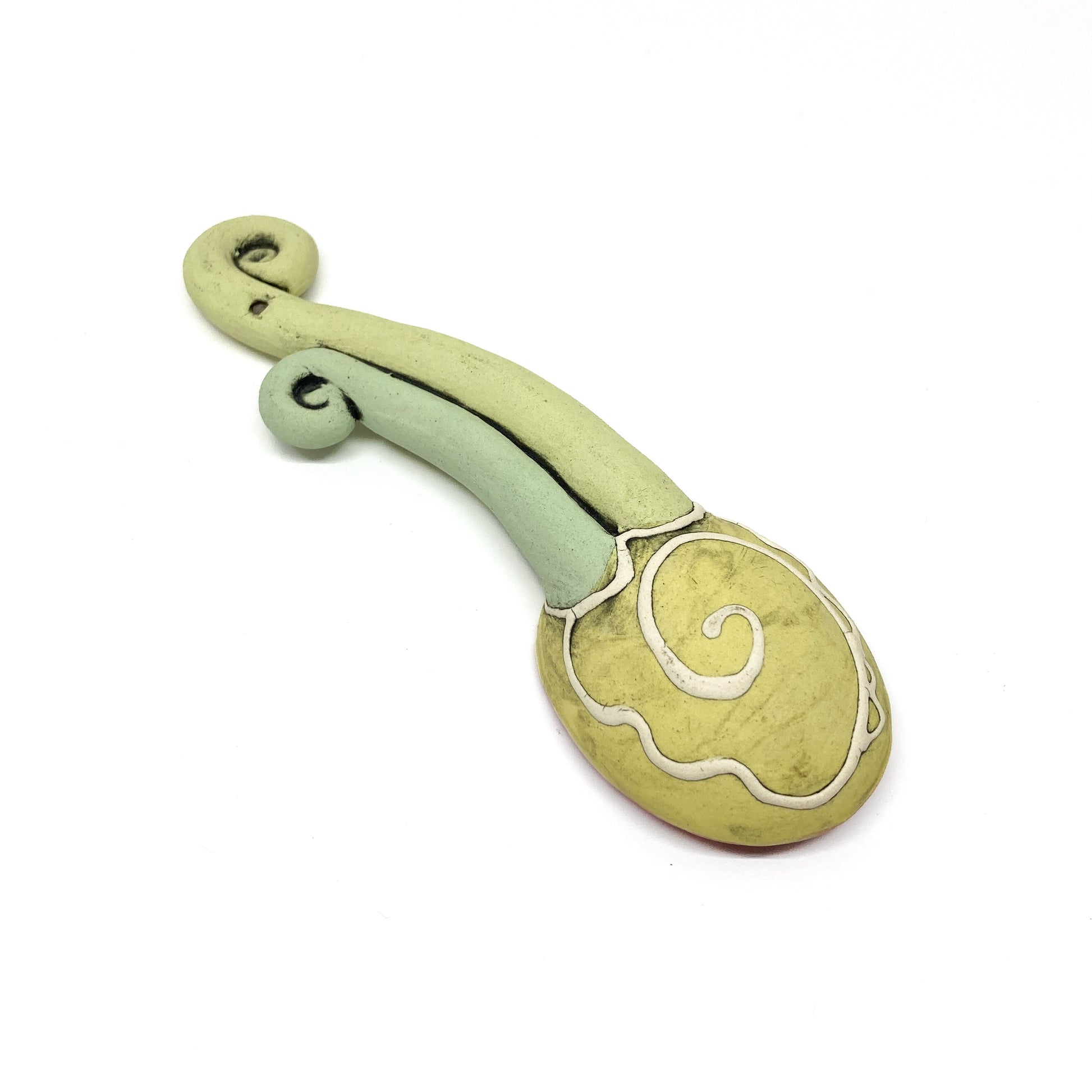 Rear view of a funky spoon with etched decorative swirl pattern and a sculpted spiral handle.