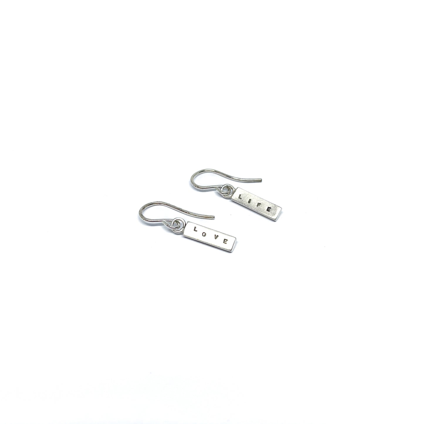 Two silver earrings with rectangular charms, one reads "LIFE" and the other "LOVE".