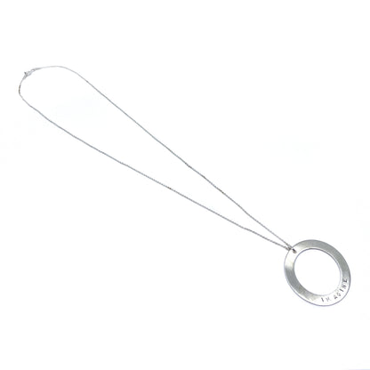 Silver necklace with a circular pendant engraved with the word "IMAGINE," lying flat.