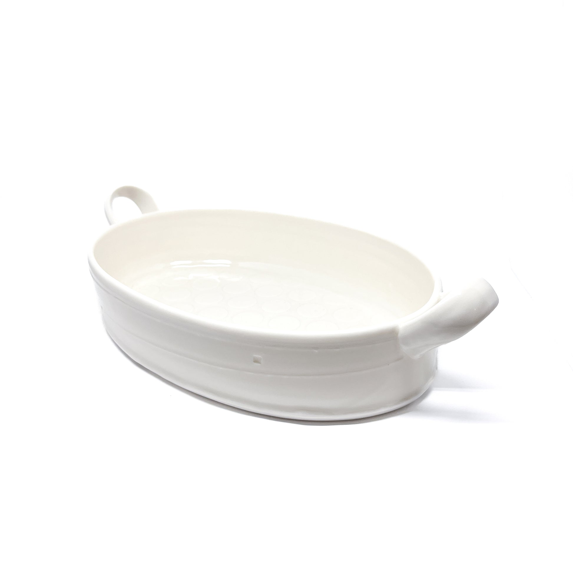 A white oval ceramic casserole dish with handles on each side.