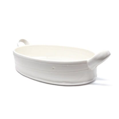 A white oval ceramic casserole dish with handles on each side.