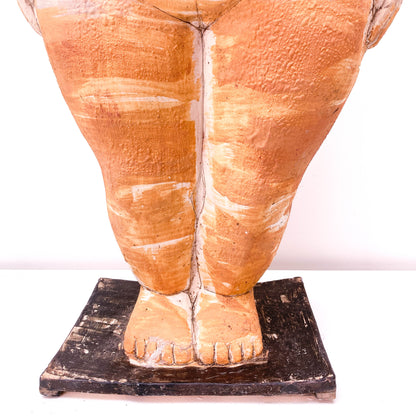 A close-up of a baby sculpture legs and feet on a black base.