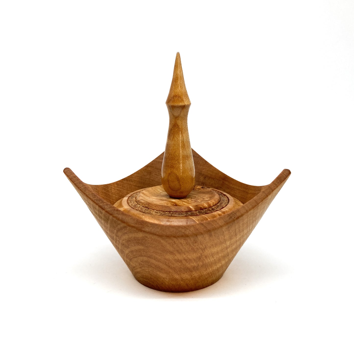 A turned wooden box with a pointed finial on the lid.