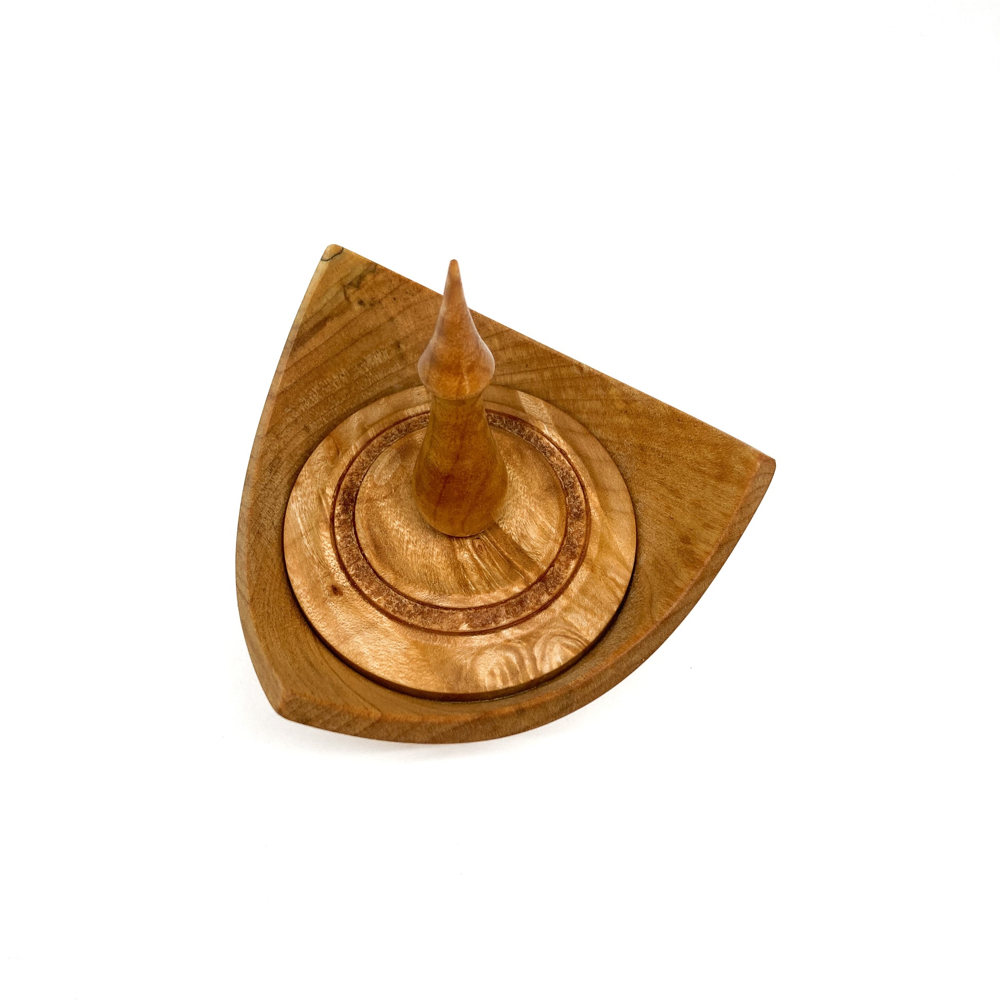 A turned wooden box with a pointed finial on the lid, viewed from above.
