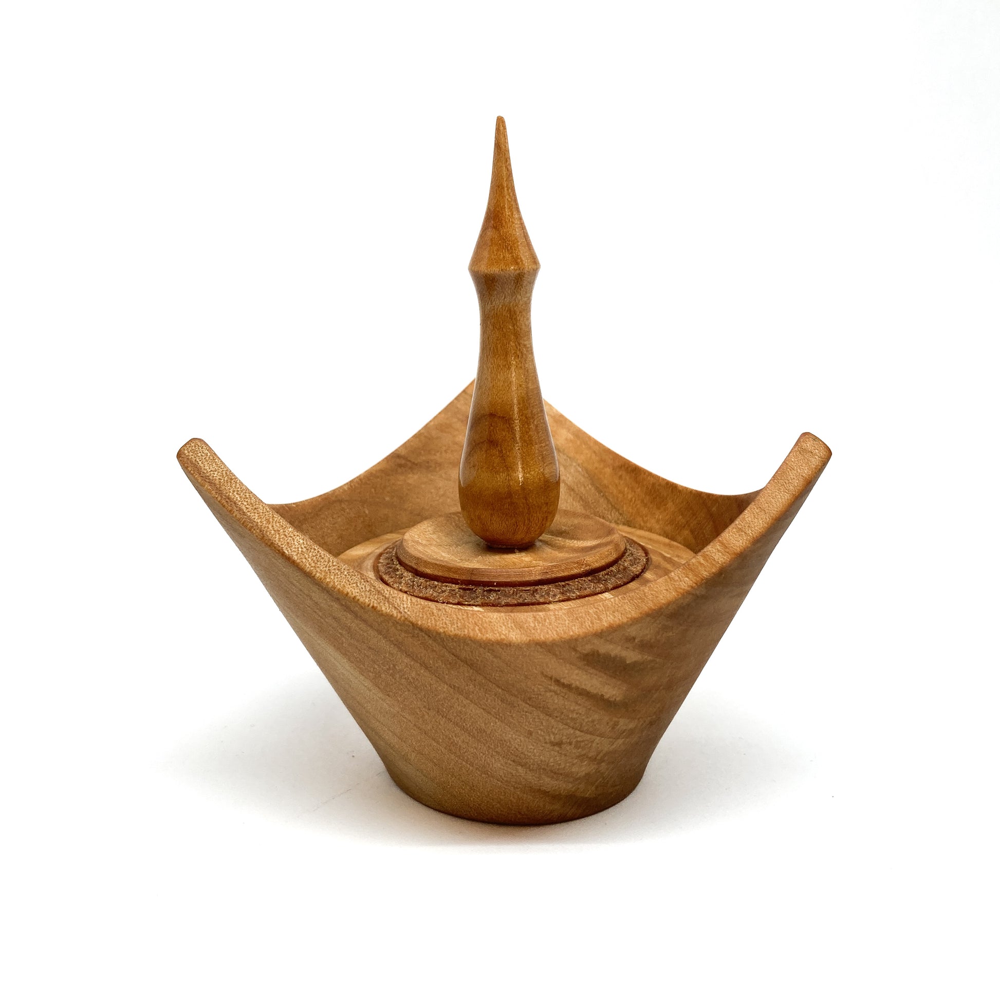 A turned wooden box with a pointed finial on the lid.
