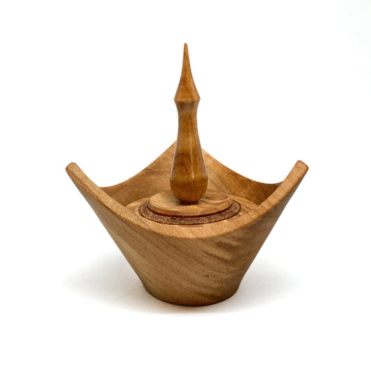 A turned wooden box with a pointed finial on the lid.