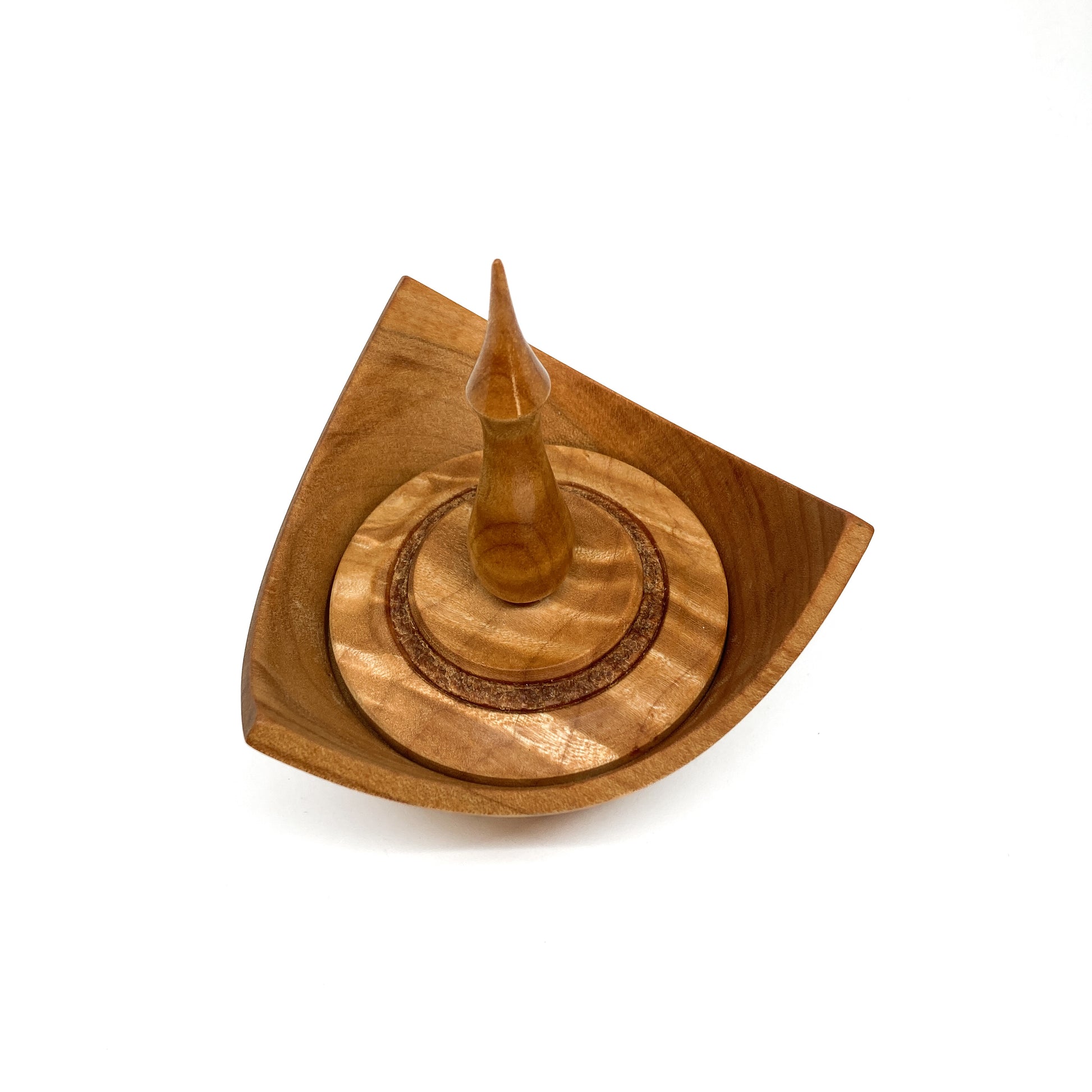 A turned wooden box with a pointed finial on the lid, viewed from above.