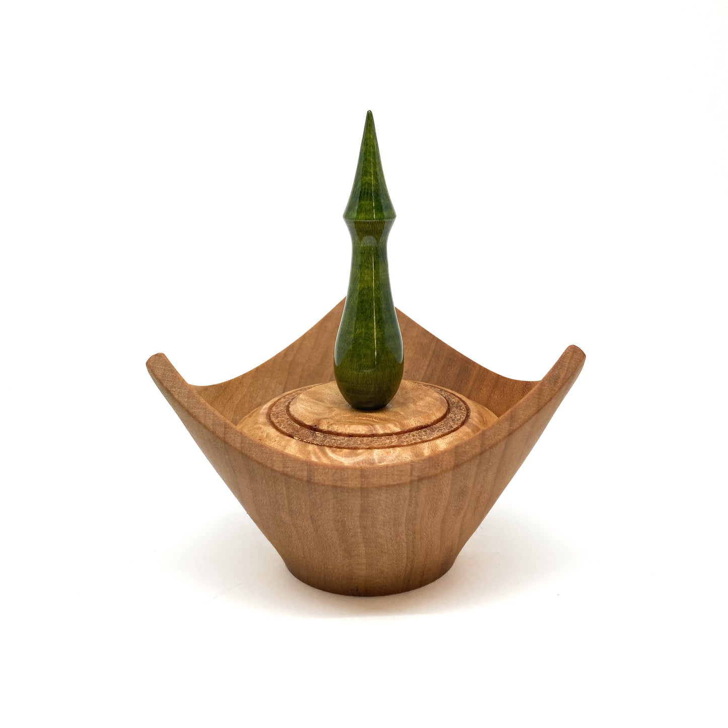 A turned wooden box with a pointed green finial on the lid.