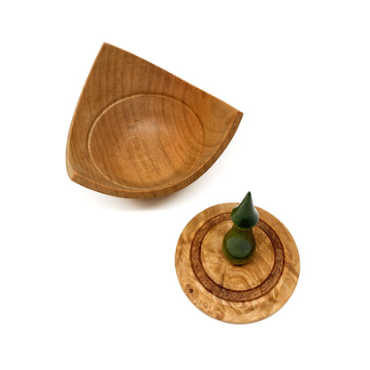 A turned wooden box with a pointed green finial on the lid, with the lid removed.