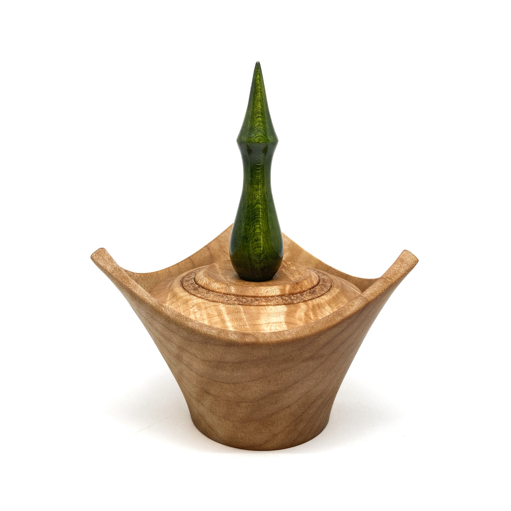 A turned wooden box with a pointed green finial on the lid.