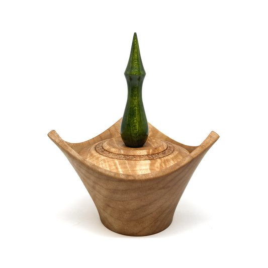 A turned wooden box with a pointed green finial on the lid.