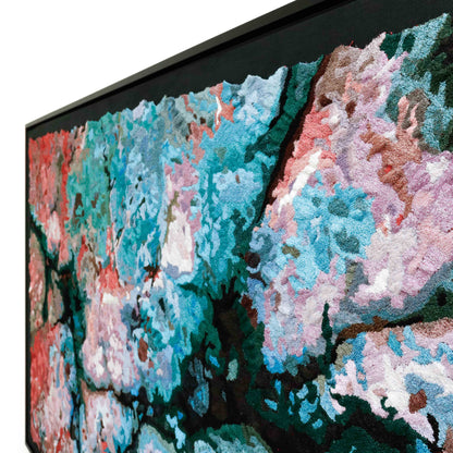 Angled view of a framed thread, showcasing dense, colorful, embroidery and stitching in an abstract design.
