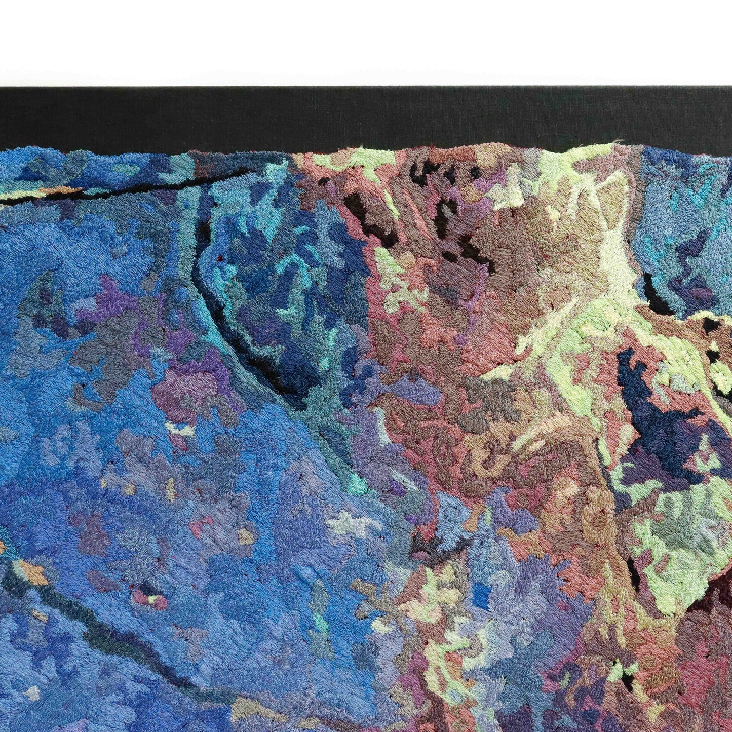 Partial view of a thread painting, showcasing dense stitching and colorful thread in a textured embroidery.