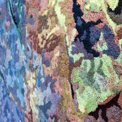 Detailed thread painting close-up, showcasing intricate stitching and a variety of colorful thread in a textured embroidery.