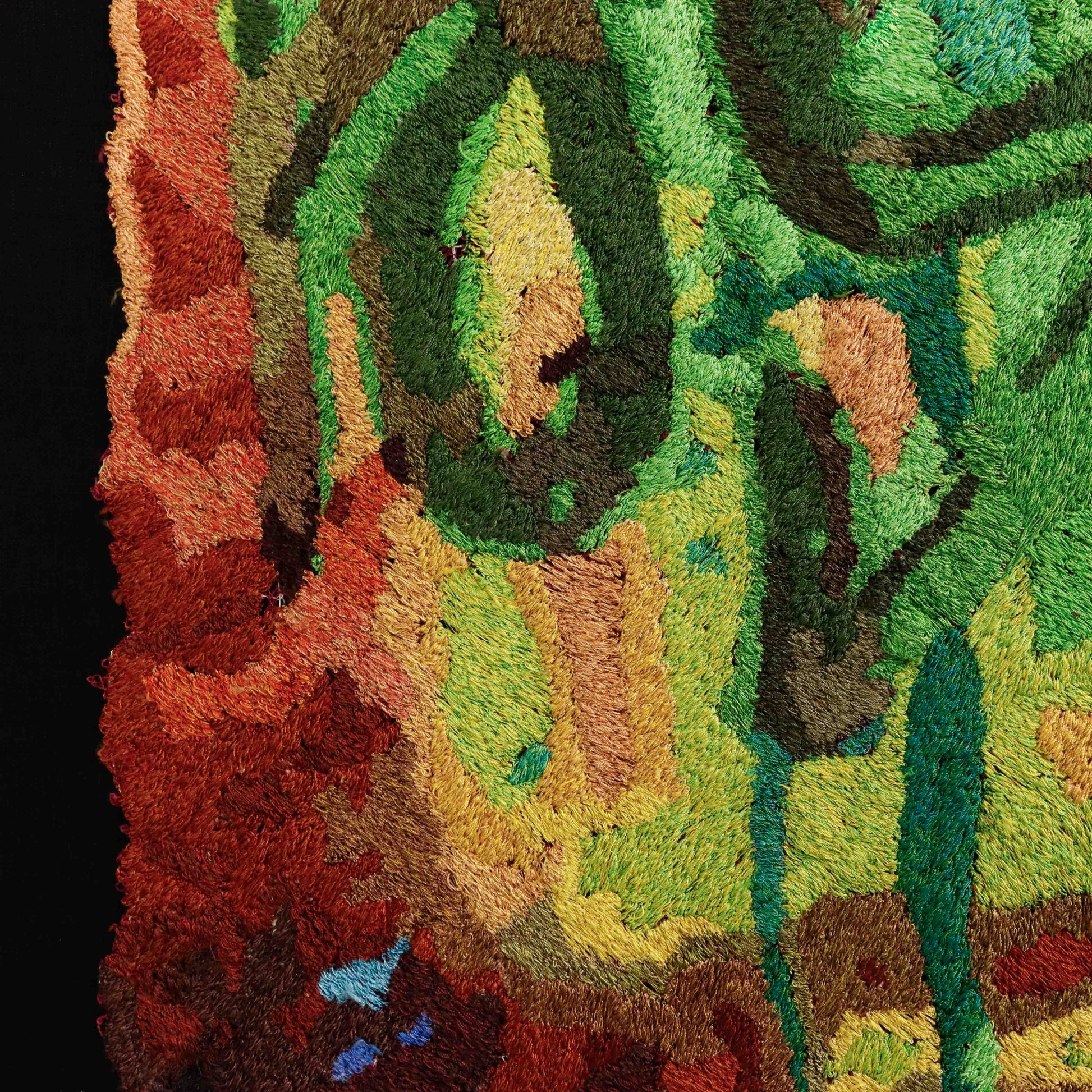 Detailed thread painting close-up, showcasing dense stitching and a variety of colorful thread in an abstract embroidery design.