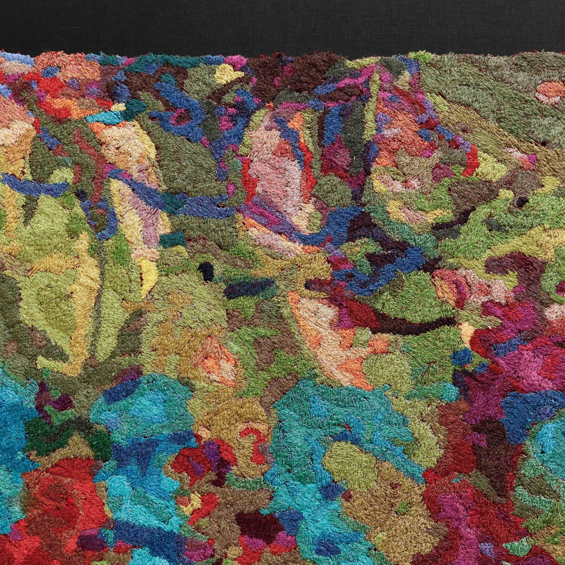 Detailed thread painting close-up, showcasing dense stitching and a vibrant array of colorful thread in an abstract embroidery.