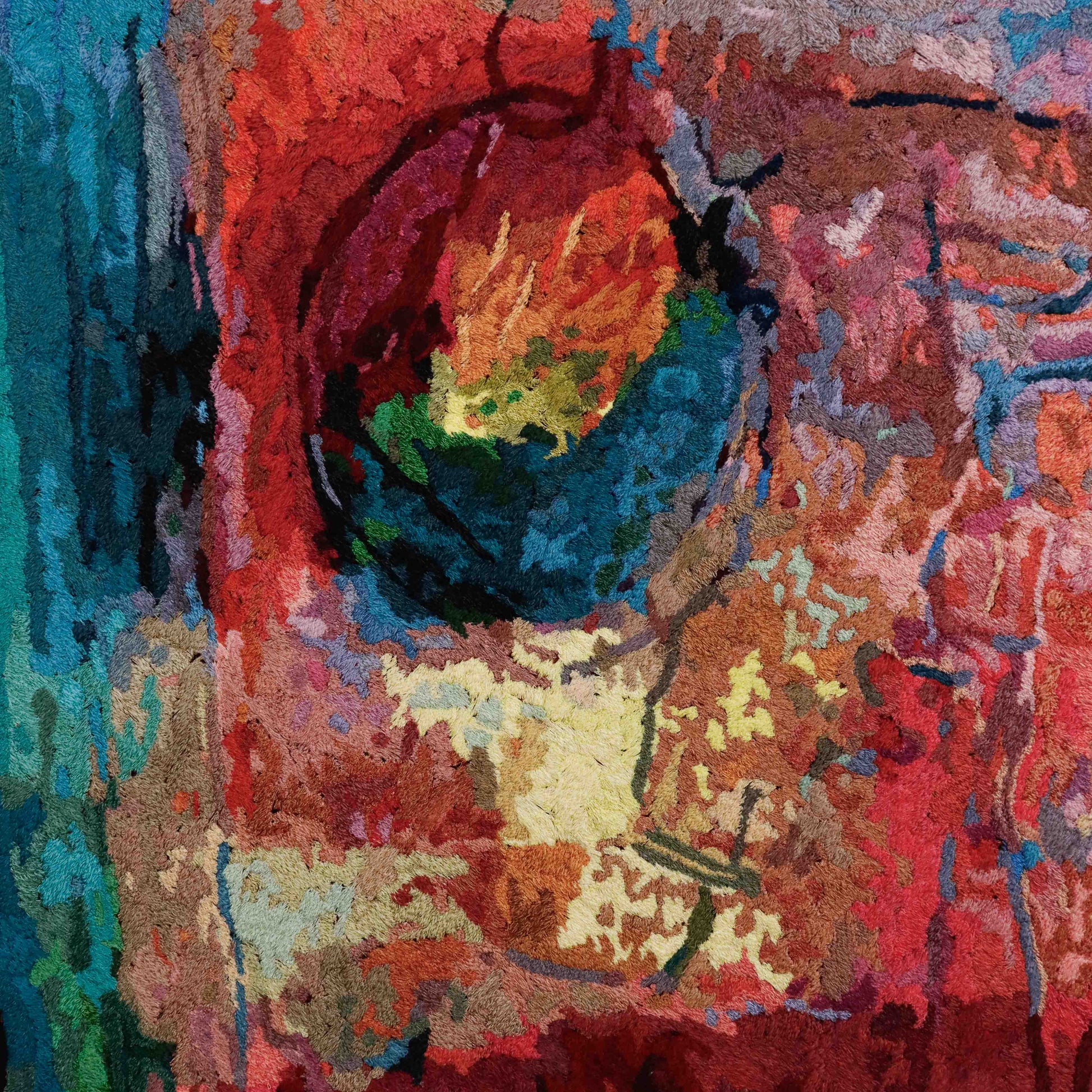 A vibrant thread painting with a circular, abstract design, showcasing detailed stitching and colorful thread.