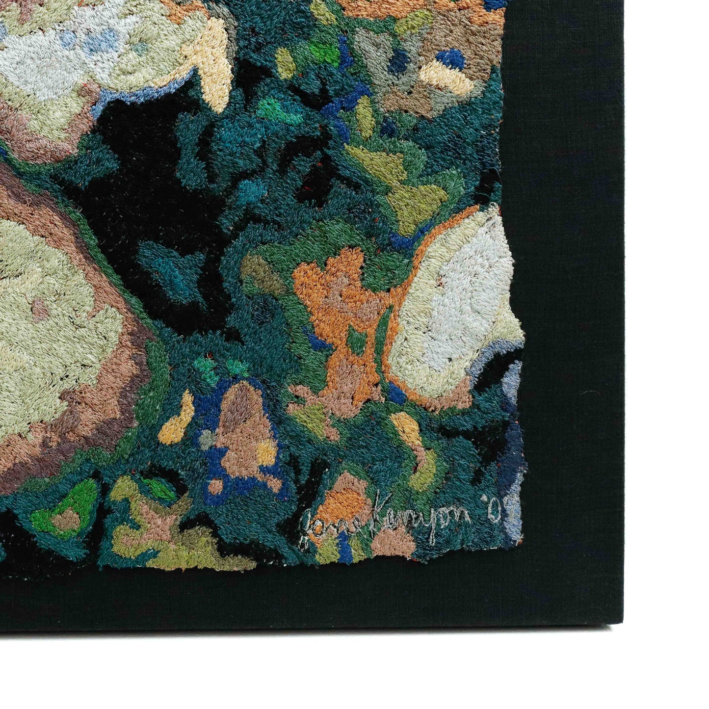 A thread painting with organic shapes, showcasing intricate stitching and colorful thread. 