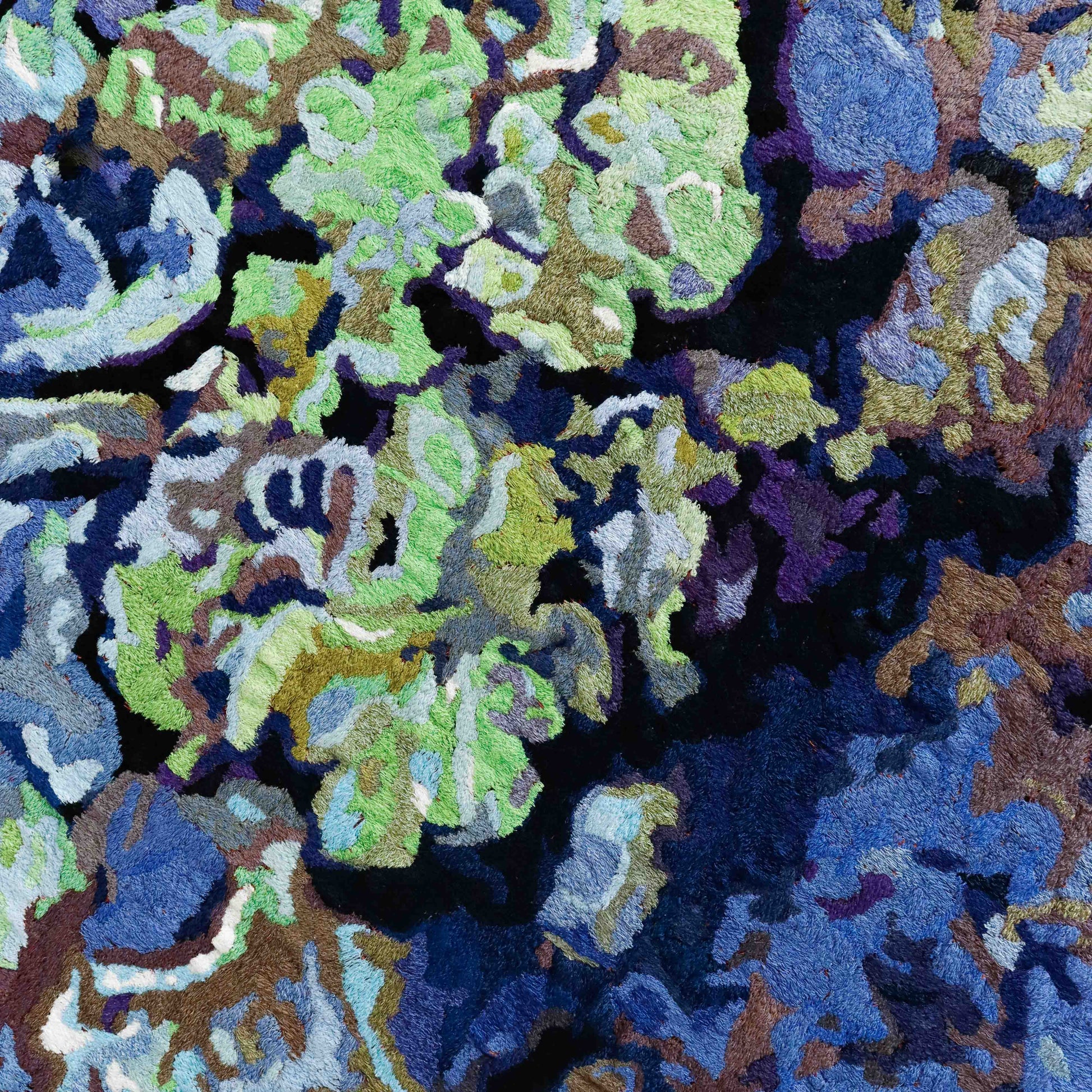 A close-up of a thread painting, highlighting detailed stitching and colorful thread in an abstract thread painting. 