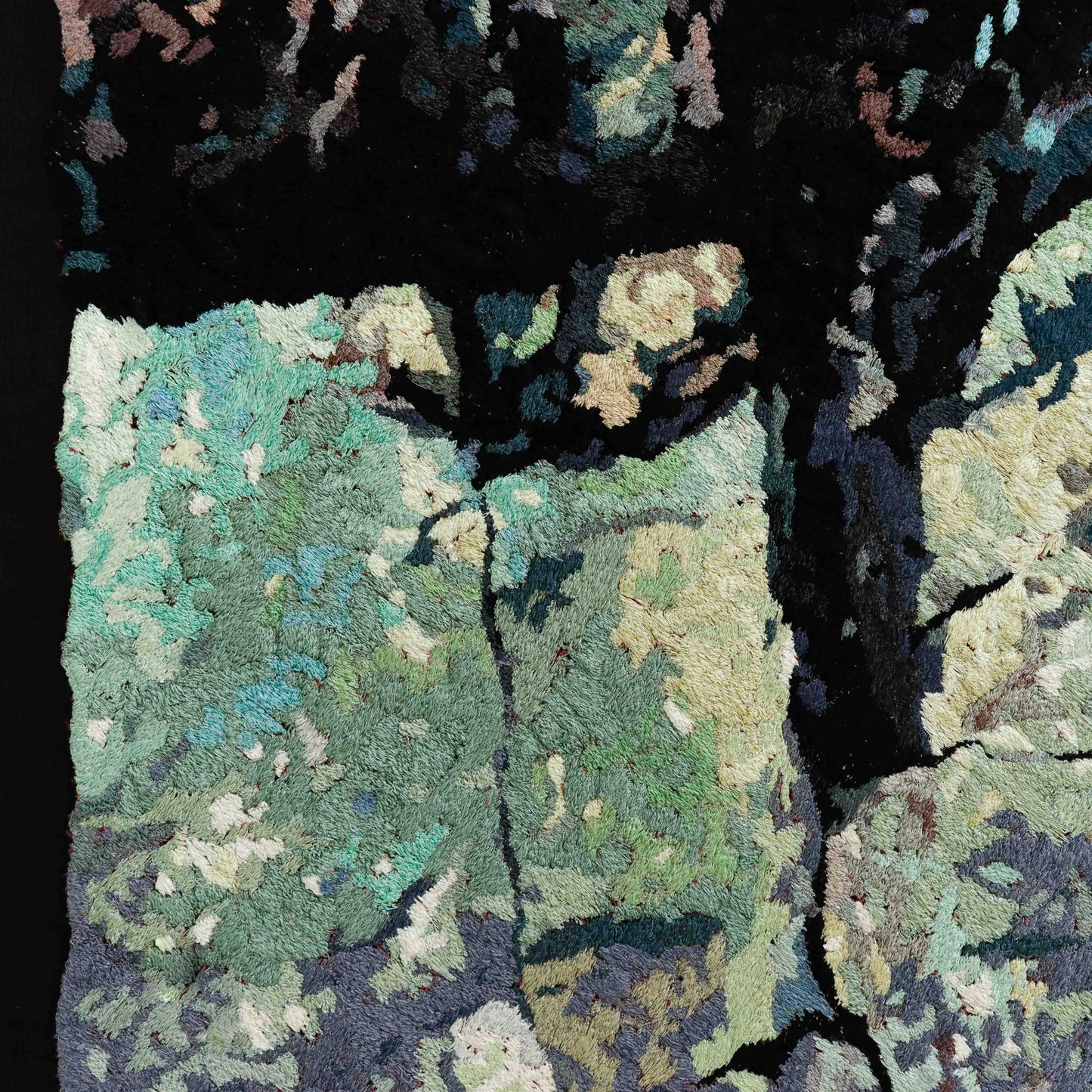 A close-up of a thread tapestry with a stone-like texture, showcasing intricate stitching and colorful thread.