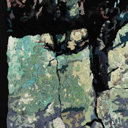 A close-up of a thread tapestry with a stone-like texture, showcasing intricate stitching and colorful thread.