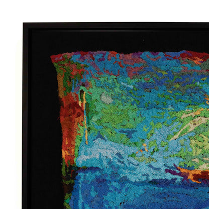 A framed thread painting, viewed from the side, showcasing intricate stitching and colorful thread in a landscape thread painting. 