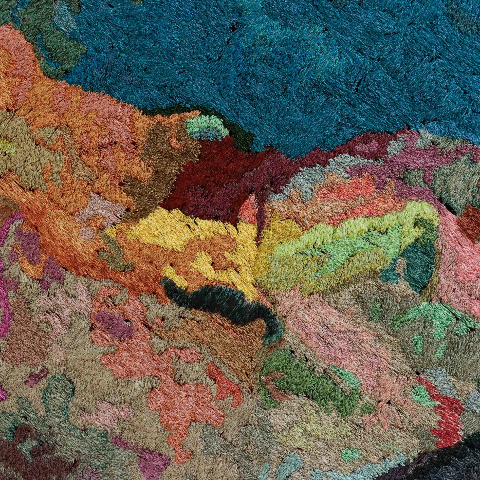 A close-up of a thread painting with a textured, abstract design, showcasing intricate stitching and colorful thread. 