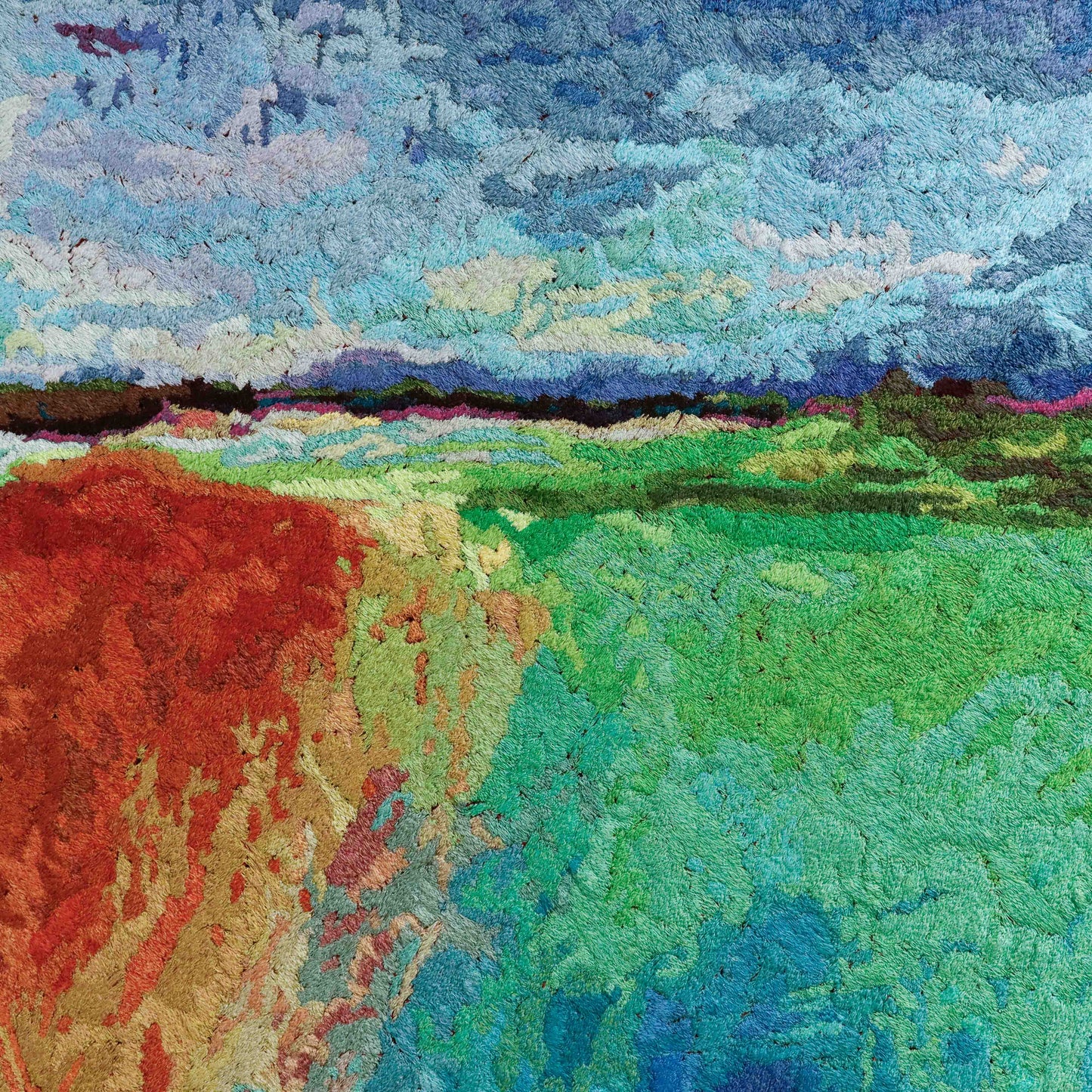 A thread tapestry with an abstract landscape design, showcasing intricate stitching and colorful thread.