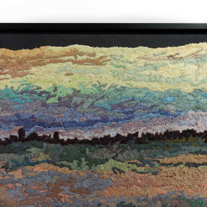 A close-up of a thread tapestry with a landscape design, showcasing intricate stitching and colorful thread.