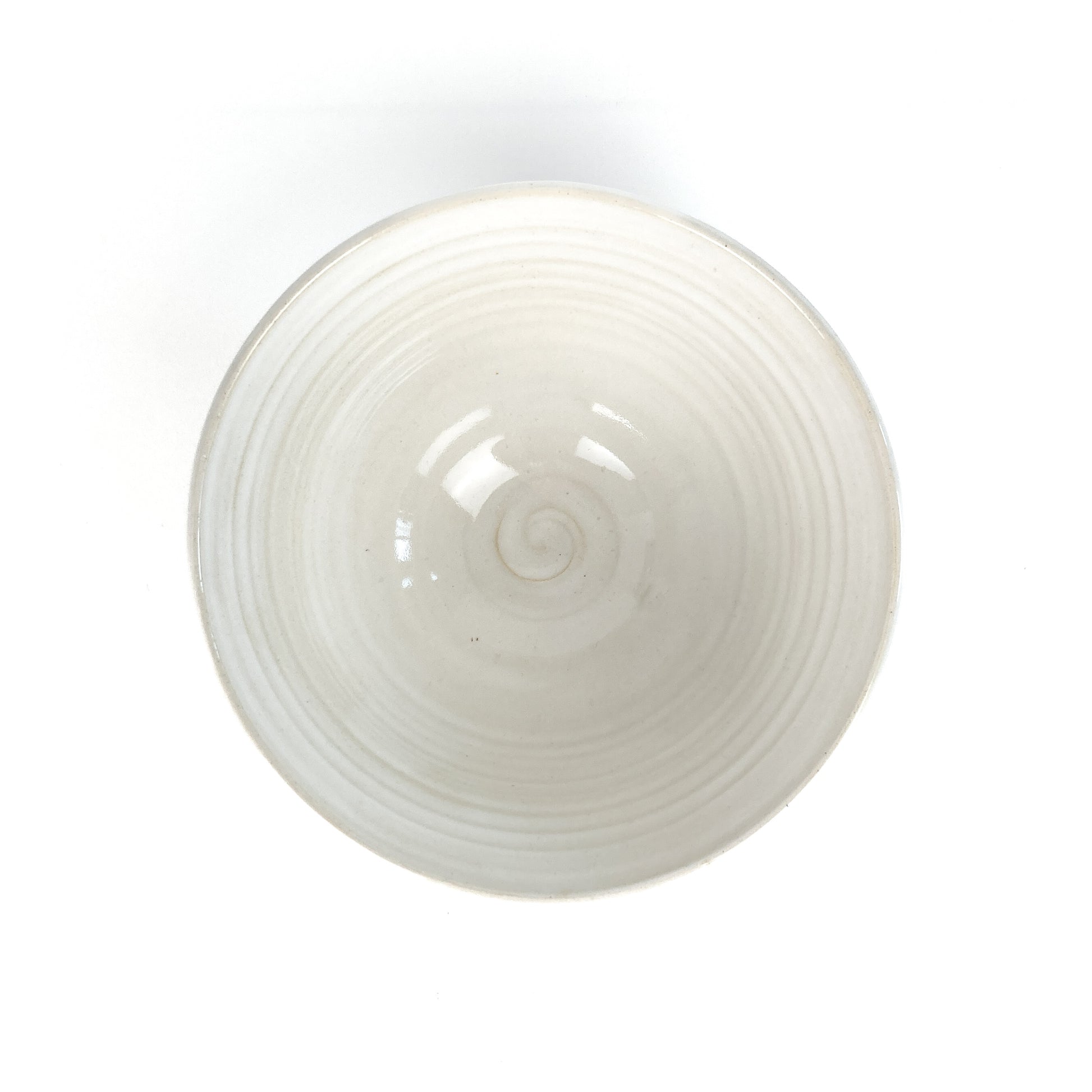 Top-down view of a white bowl with a subtle spiral pattern in the center.