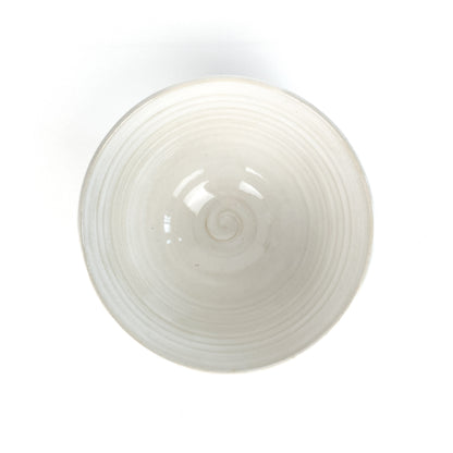 Top-down view of a white bowl with a subtle spiral pattern in the center.