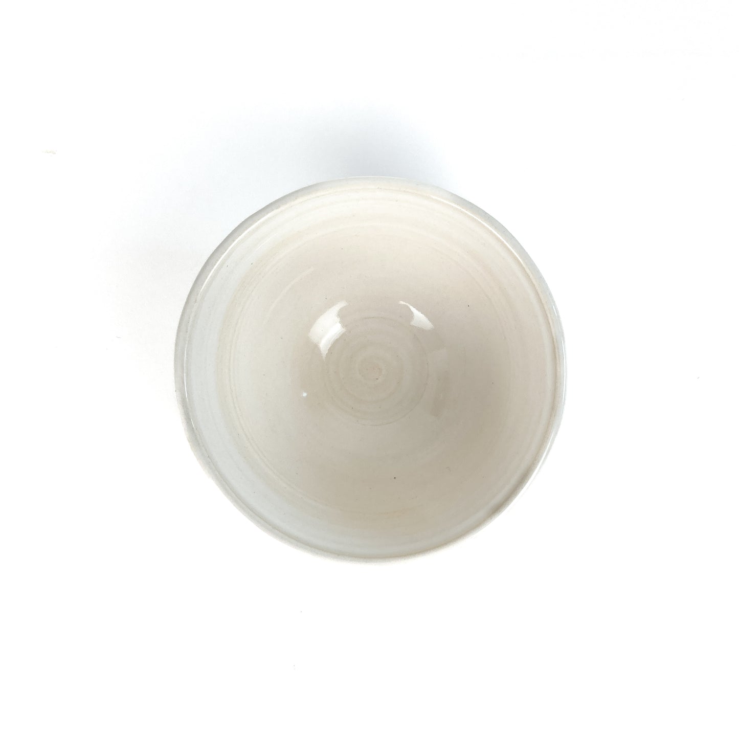 Top-down view of a white bowl with a subtle spiral pattern in the center.