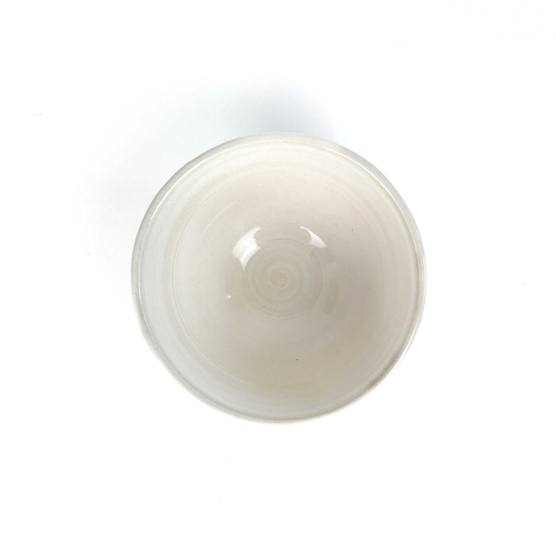 Top-down view of a white bowl with a subtle spiral pattern in the center.