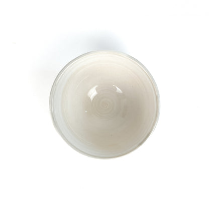 Top-down view of a white bowl with a subtle spiral pattern in the center.