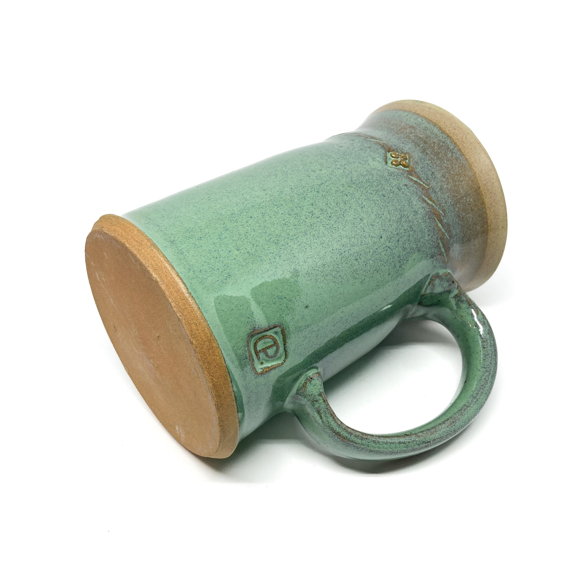 Angled view of a seafoam green glazed ceramic stein showing the unglazed base, rope design, and maker's mark.
