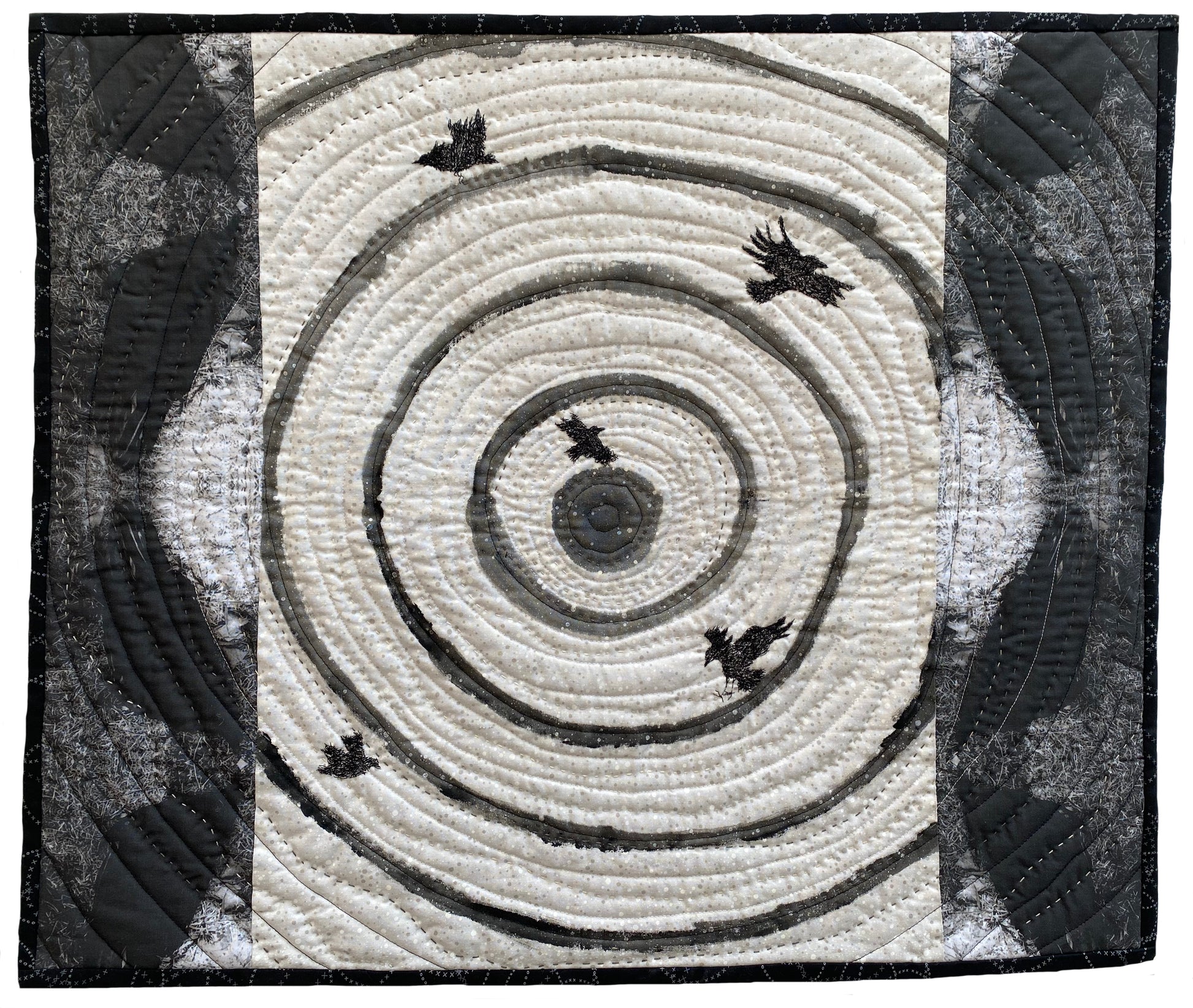 Textile art: concentric swirling lines with five dark birds scattered across the design.